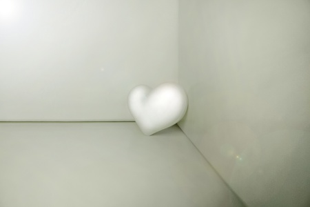 White plastic heart placed ina a cornerの写真素材