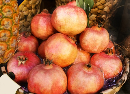 Pomegranates in a basket with a pineappleの写真素材