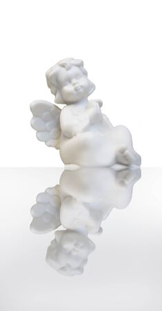 A statue of a sweet little angel on white with his reflectionの写真素材