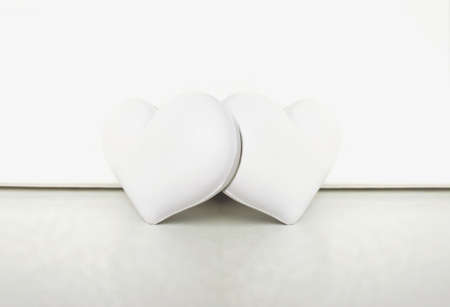 Two white hearts together in the white backgroundの写真素材