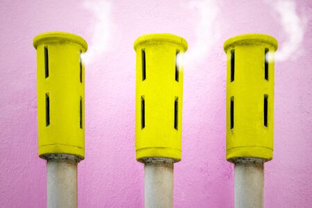 Abstract detail of three yellow chimneys on purple backgroundの写真素材