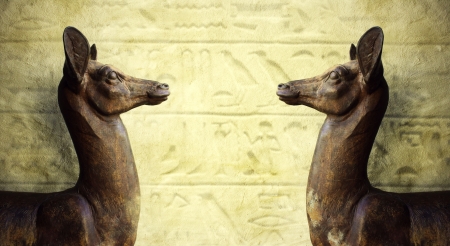 Two wonderful Egyptian statues profile that look each other with hieroglyphic on the backgroundの写真素材
