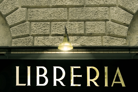 Detail of an elegant twenties italian style ensign of a library with a vintage lamp that illuminates the writtenの写真素材