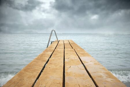 Detail of a pier in a sea in a gloomy day