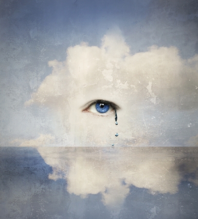 Fantasy concept of a human eye crying in the clouds の写真素材
