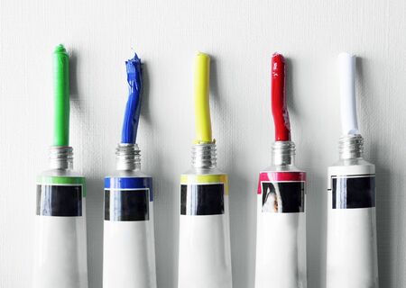Detail of five colored tubes of oil on white backgroundの写真素材