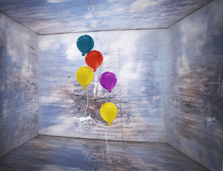 Fantasy box inside with sky and clouds on the walls and wooden texture with five colorful balloons that flying inside of itの写真素材