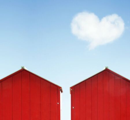 Colorful abstract concept of love, two red cabin with blue sky and a cloud in the shape of heart on the backgroundの写真素材
