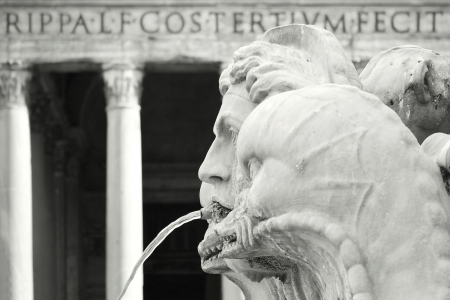 Black and white picture of a detail of a beautiful profile of a fountain with the columns of the Pantheon in the backgroundの写真素材
