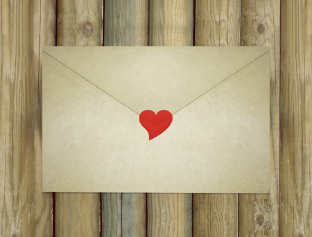 A love letter envelope enclosed by a red heartの写真素材