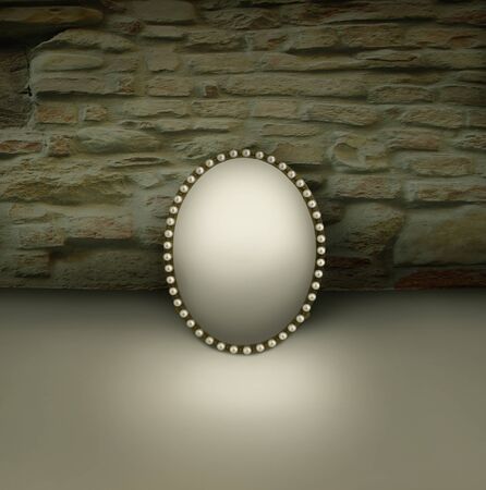 Small mirror with vintage frame decorated in pearls on a brick wall backgroundの写真素材