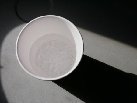 Sparkling water in a paper cup on a gray background, top viewの写真素材