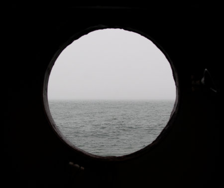 View of the sea through the window of a ship in the fogの写真素材