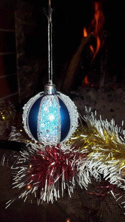 Christmas decoration blue glass ball with garland and fire backgroundの写真素材
