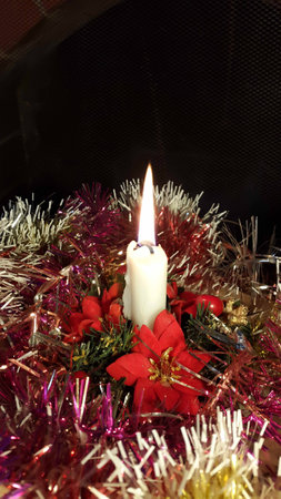 Xmas White Candle light closeup with tinsel and dark backgroundの写真素材