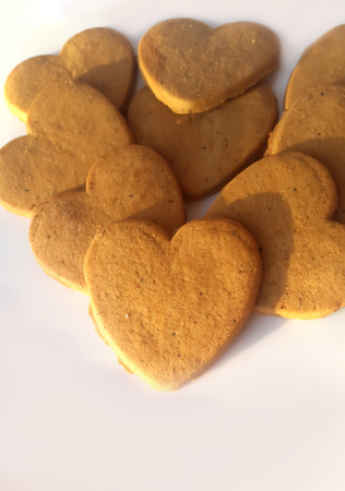 Several heart shaped ginger snap cookies on a white background.の写真素材