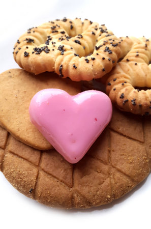 Sweet red marzipan heart and Crunchy fresh biscuits on a white backgroundの写真素材