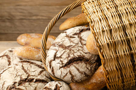 Several loaves of fresh bread spilled out of the basket. front view.
