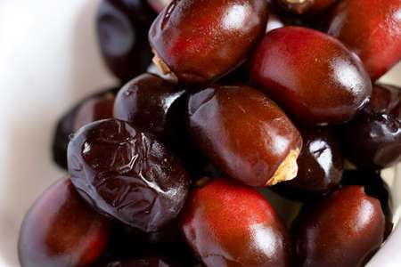 Beautiful Tasty Fresh Dark Red Dates Fruit Or Date Palm In White Background. Selective Focusの写真素材