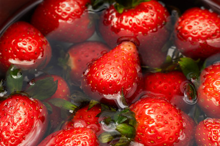 Closeup Image Of Strawberries Soaking In Clear Waterの写真素材