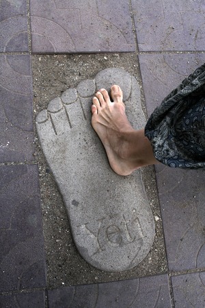 A large stone foot  Yeti and a small female footの写真素材