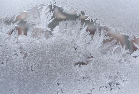 Close-up of beautiful delicate frosty pattern on winter window glass.の写真素材