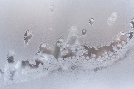 Undulating beautiful frosty pattern on frozen winter window glass.の写真素材