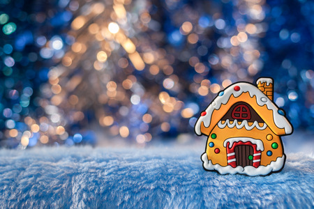 Small decorative house, simulating gingerbread on a beautiful Golden-blue bokeh background....