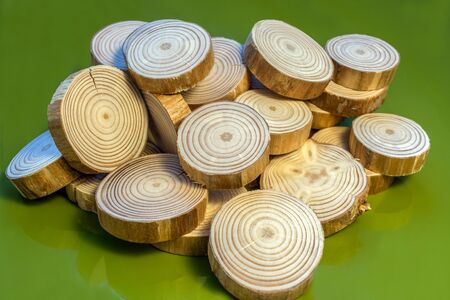 Bunch of randomly stacked pine saw cuts are lying on glossy green surface.の写真素材