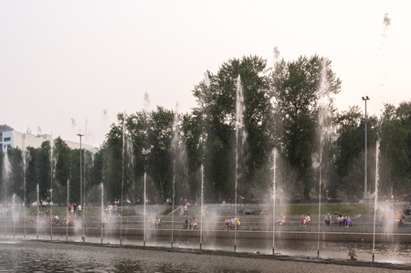 Yekaterinburg, Russia - July,22,2016: Fountains in the Historic Square in center of the city in hot summer evening. Behind streams of water are seen resting people.のeditorial素材