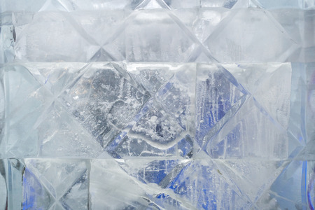 Close-up texture of cube of ice with carved equal squares.