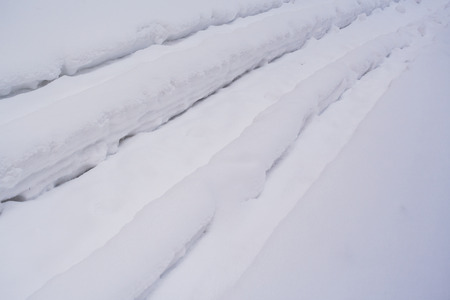 Natural texture. Winter background. Close-up texture of white deep snowy ruts located diagonally.の写真素材