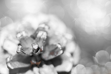 Abstract silver christmas black and white background with soft focus. Contours of spruce cone colored in silver and beautiful shining bokeh with asterisks.の写真素材