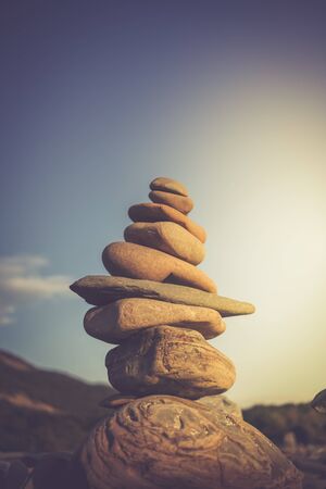 Stack of stones symbolizing Zen against sky. Toned image.