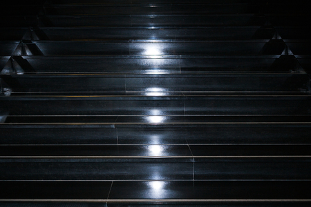 Abstract minimalistic geometric background as black granite staircase with vertical stripe of  white lighting spots in the middle.の写真素材
