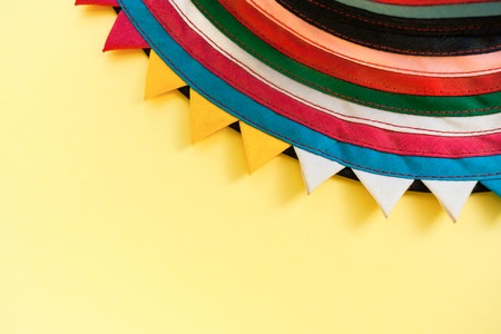 Semicircular handmade cloth of stitched from colorful stripes on top of bright pastel yellow...