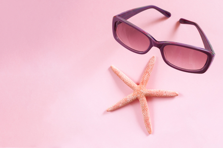 Purple sunglasses and starfish on pink background.の写真素材