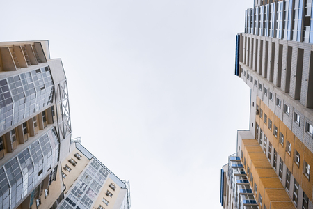 Low angle view tops of facades of vivid modern gray-yellow residential buildings .の写真素材