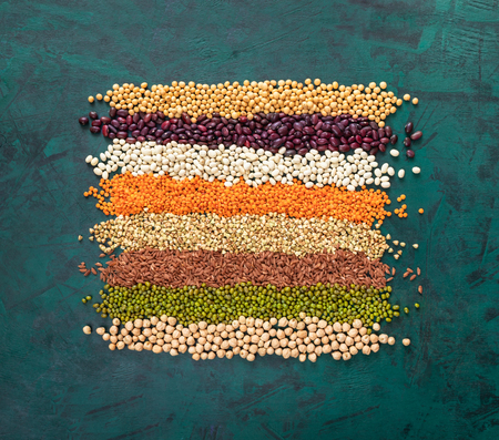 Square of superfoods laid out stripes, in middle of textured emerald green background.の写真素材