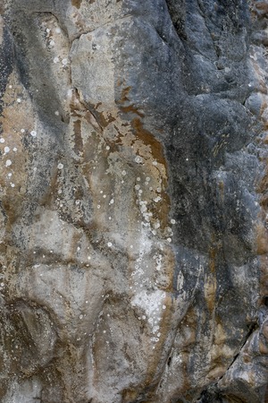 Natural stone background of rock formation with uneven bulging surface.