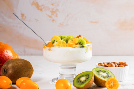 Glass bowl on stem with yogurt and fresh fruit on white background.の写真素材