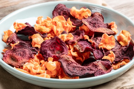 Close-up turquoise plate with chips from carrot and beetroot.の写真素材