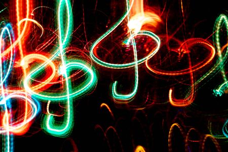 Close-up red and green neon glowing treble clefs. Abstract  luminous background.の写真素材