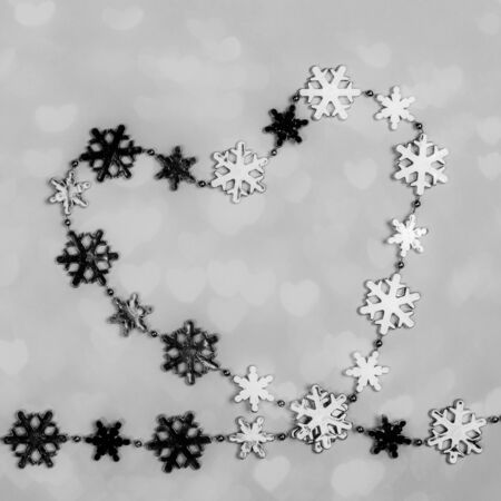 Creative black and white Valentines day background. Heart of shiny metallic snowflakes in hearts shape.の写真素材