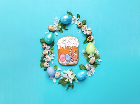 Colored hen eggs, quail eggs, white Apple tree flowers laid out as Easter egg with gingerbread in...