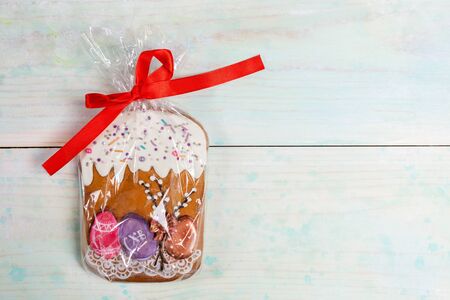 Easter festive decoration. One gingerbread Easter cake packed in cellophane with red ribbon as gift...