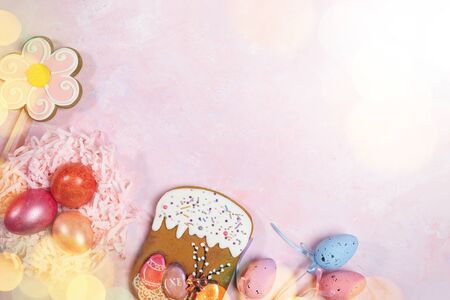 Easter festive background with colored eggs, Easter gingerbreads and bokeh overlay on pink backdrop....