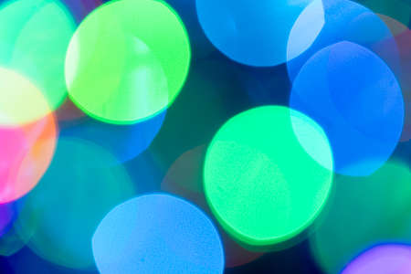Christmas or New Year festive blue and green bokeh background closeup. Large Xmas macro round bokeh backdrop.の写真素材