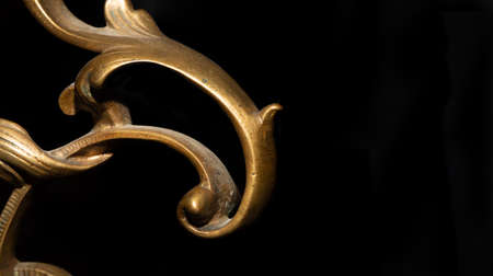 Antique abstract backdrop. Bronze curved metal decor on cracked black wood. Copyspace. Macro of...