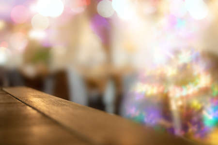 Cozy Christmas blur background with bokeh, tables, Christmas tree in living room or in cafe and...